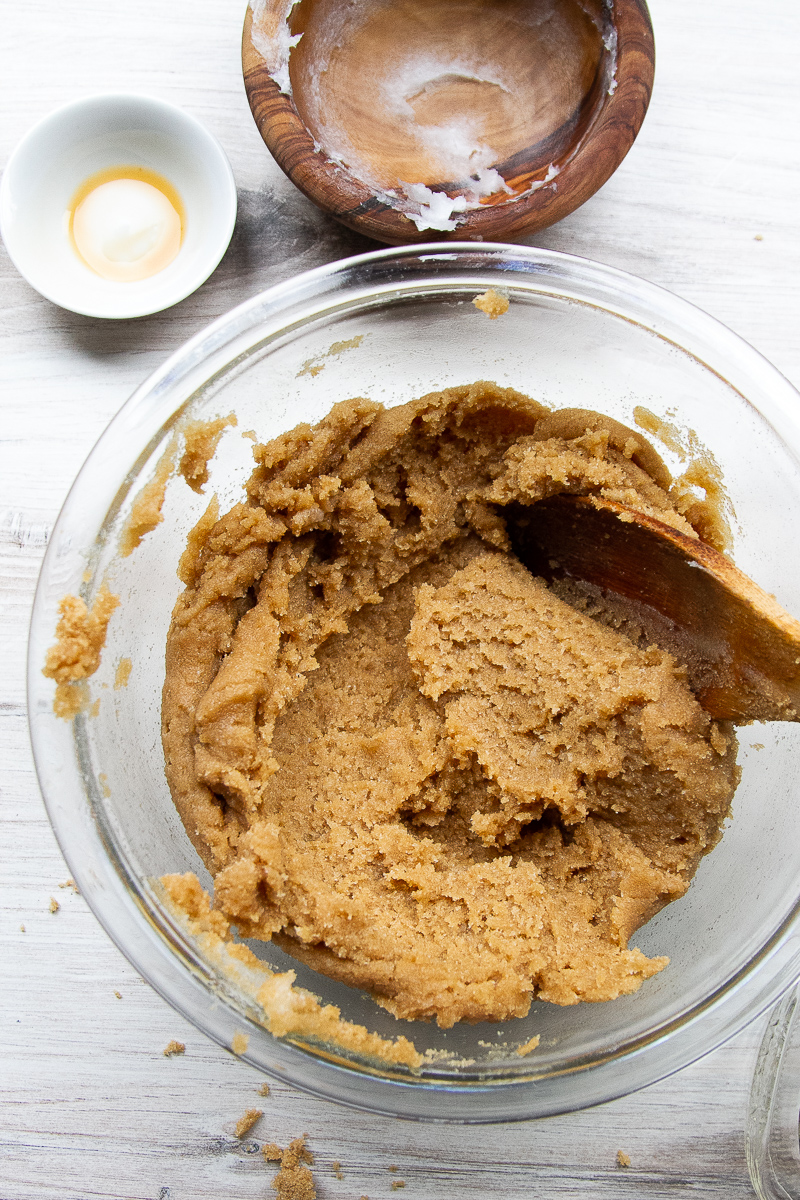Brown sugar, coconut oil, and vanilla mixed in a clear mixing bowl.