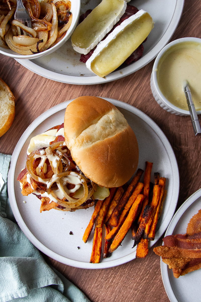 Assembled burger overhead shot on a plate with some sweet potato oven fries. 