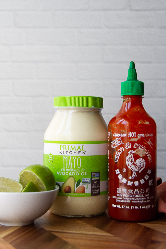 Most of the ingredients for spicy mayo: sriracha sauce, mayonnaise, and limes.