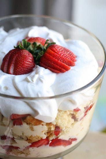 Strawberry Holiday Trifle (with gluten and dairy-free adaptations) | strawberry recipes | dessert recipes | Strawberry Trifle in a glass dish topped with whipped cream and strawberries.