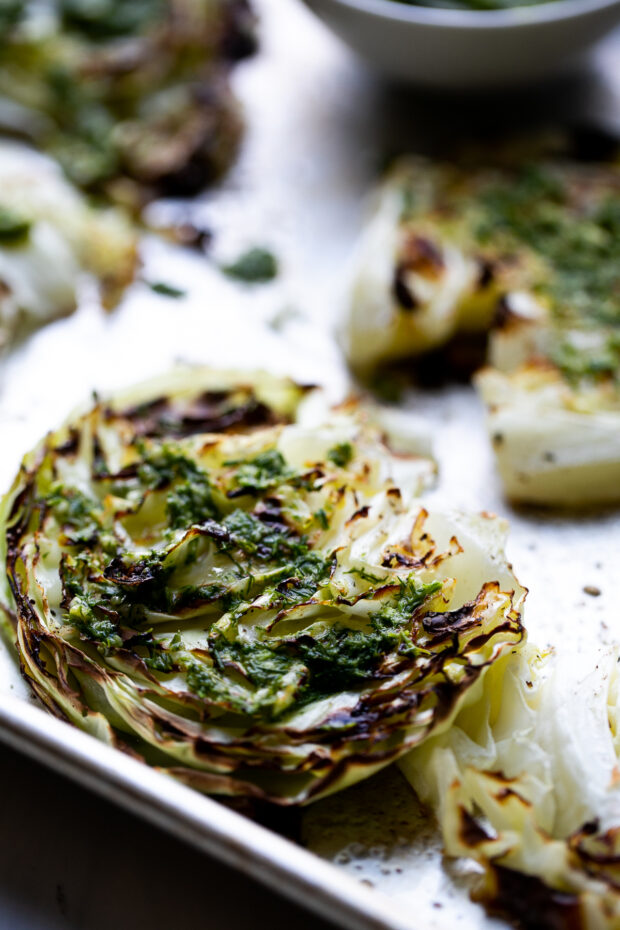 Another shot of a roasted cabbage steak with pesto on top.