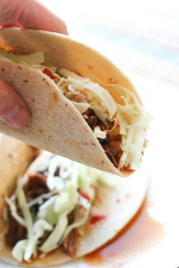 If you love that drippy, flavorful shredded beef in tacos from those hole-in-the-wall places, you HAVE to try this. It's easy to make a big batch of this shredded beef in your slow cooker! | perrysplate.com If you love that drippy, flavorful shredded beef in tacos from those hole-in-the-wall places, you HAVE to try this. It's easy to make a big batch of this shredded beef in your slow cooker! | perrysplate.com