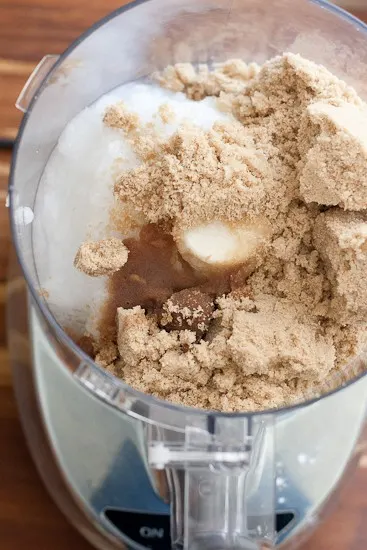 Food processor work bowl with brown sugar and coconut oil.