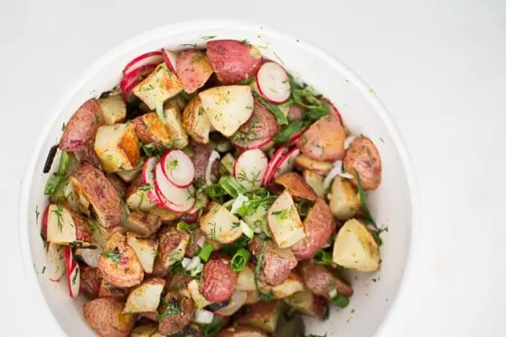This is a fresh, mayo-free take on a potato salad. Tender roasted potatoes are tossed with a herby, mustardy vinaigrette. You'll never go back to regular potato salads. | perrysplate.com 