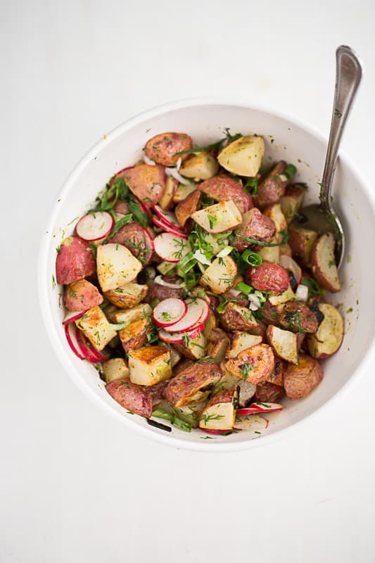 This is a fresh, mayo-free take on a potato salad. Tender roasted potatoes are tossed with a herby, mustardy vinaigrette. You'll never go back to regular potato salads. | perrysplate.com 