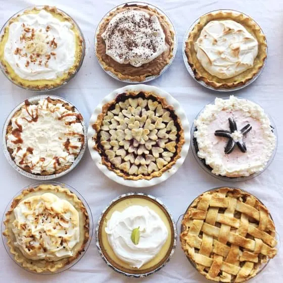 Perfect Gluten-Free Pie Crust -- Even better than most traditional pie crusts! | perrysplate.com | gluten-free recipes | gluten-free baking View of 9 different kinds of pie laid out on a table in a grid.