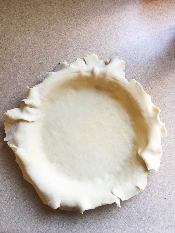 Pie crust dough laid in a pie crust dish.