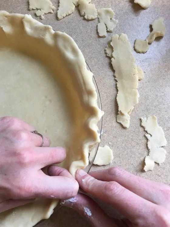 Perfect Gluten-Free Pie Crust -- Even better than most traditional pie crusts! | perrysplate.com | gluten-free recipes | gluten-free baking View of the pie crust dough being trimmed and crimped.