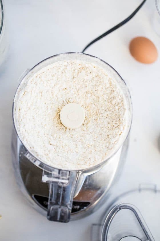 Cold butter cut into the gluten-free flour mixture in the work bowl of a food processor.