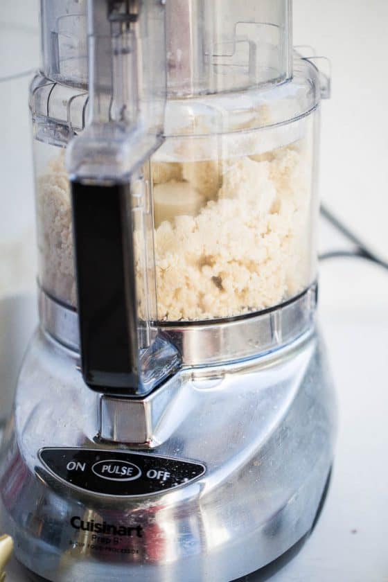 Gluten-free pie crust dough blended up and chunky in a food processor.