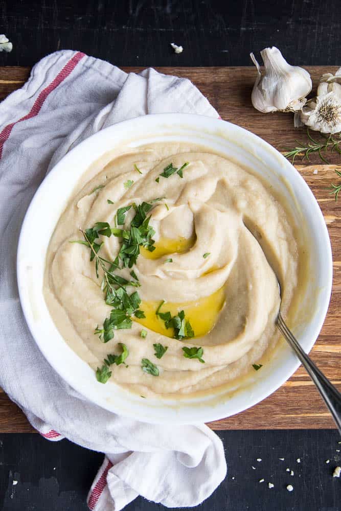 Big serving bowl with Cauliflower Puree with Rosemary & Garlic. Chopped parsley and extra butter on top for garnish.