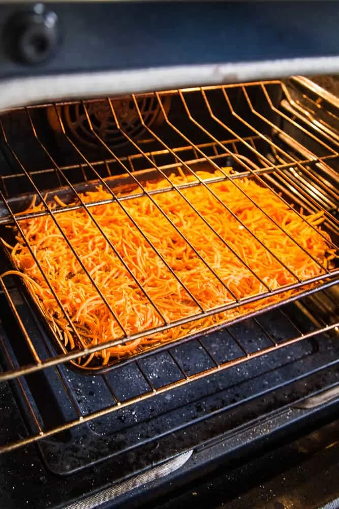 The secret of making crispy sweet potato hash browns is roasting them on a hot pan with plenty of bacon drippings or ghee. Step by step tutorial over at perrysplate.com! | sweet potato recipes | paleo recipes | Whole30 recipes