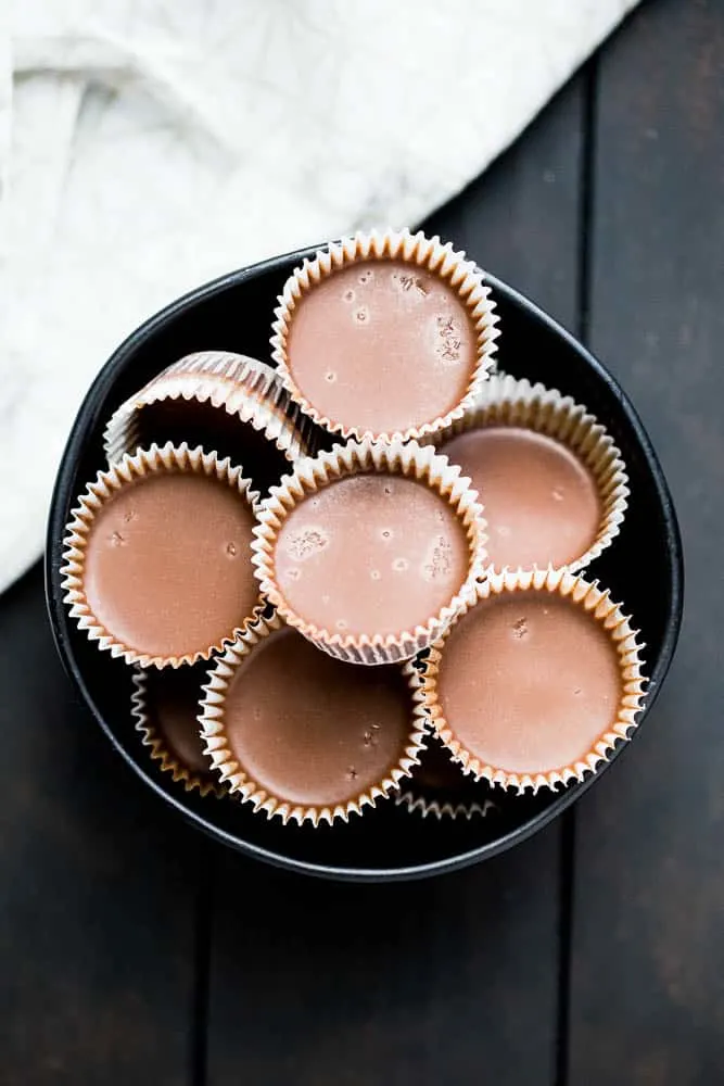 These little keto chocolate tahini fat bombs taste like a peanut butter cup without the nuts! They come together quickly and easily and will help keep your face out of the Reese's bag. | low-carb recipes | low carb high fat | perrysplate.com