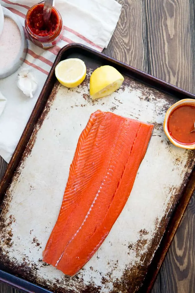 This spicy Harissa Roasted Salmon is a summertime favorite! There are only 5 ingredients and you can make it on the grill, too. Perfect for palo, keto, and Whole30 eaters. | perrysplate.com 