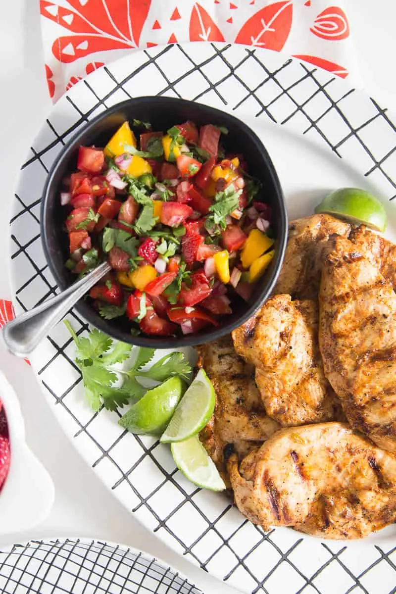 Chipotle-Lime Grilled Chicken with Strawberry Mango Salsa might be my favorite meal of the summer. It's easy to throw the chicken into a marinade ahead of time, and the kids all loved it! | perrysplate.com #grilledchicken #mangosalsa #summerrecipes