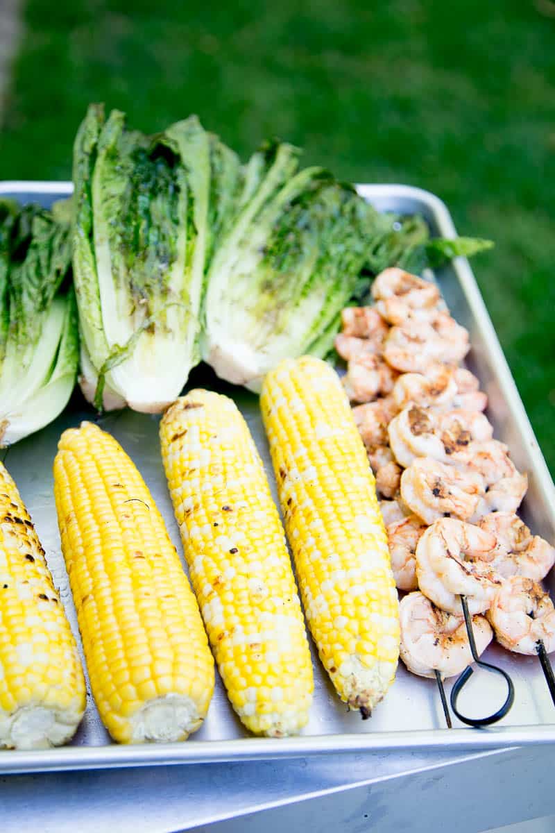 This is a fun, Southwest twist on a Caesar Salad with grilled romaine. (Yes, you can grill lettuce! It works!) The Cilantro-Lime Caesar Dressing is my favorite part. | perrysplate.com #caesarsalad #grilledshrimp #grilledcorn