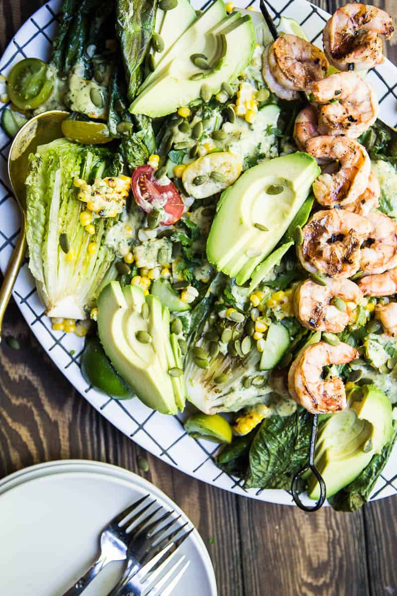 This is a fun, Southwest twist on a Caesar Salad with grilled romaine. (Yes, you can grill lettuce! It works!) The Cilantro-Lime Caesar Dressing is my favorite part. | perrysplate.com #caesarsalad #grilledshrimp #grilledcorn
