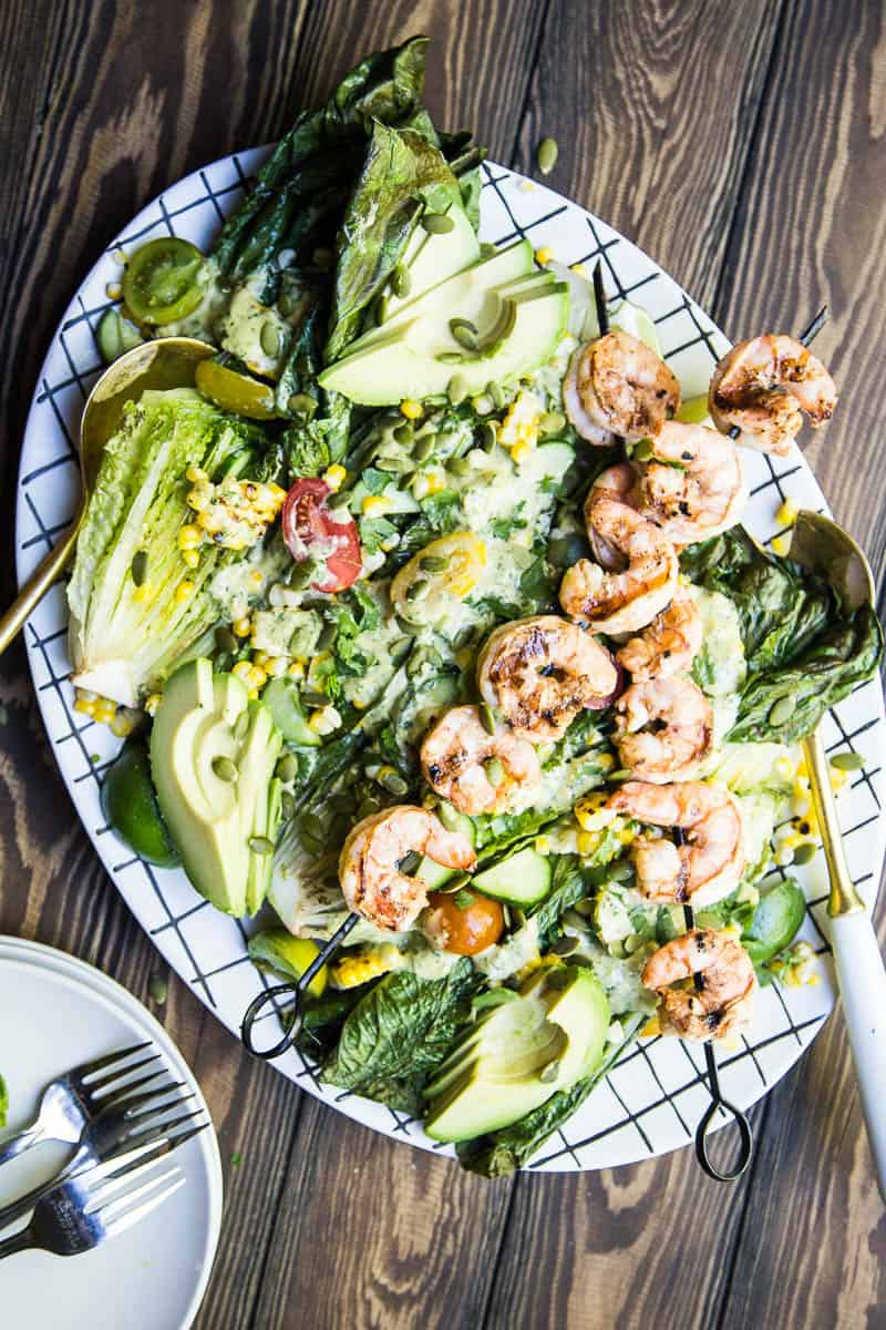 This is a fun, Southwest twist on a Caesar Salad with grilled romaine. (Yes, you can grill lettuce! It works!) The Cilantro-Lime Caesar Dressing is my favorite part. | perrysplate.com #caesarsalad #grilledshrimp #grilledcorn
