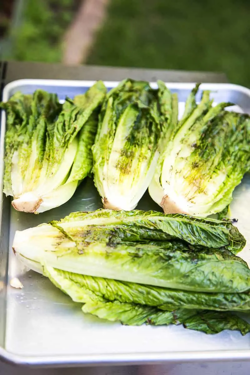 This is a fun, Southwest twist on a Caesar Salad with grilled romaine. (Yes, you can grill lettuce! It works!) The Cilantro-Lime Caesar Dressing is my favorite part. | perrysplate.com #caesarsalad #grilledshrimp #grilledcorn