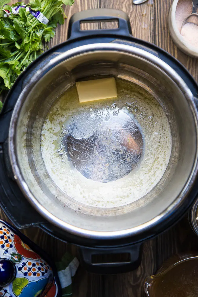 Melt the butter for the Instant Pot Cilantro Lime Rice | PerrysPlate.com #instantpotrecipes