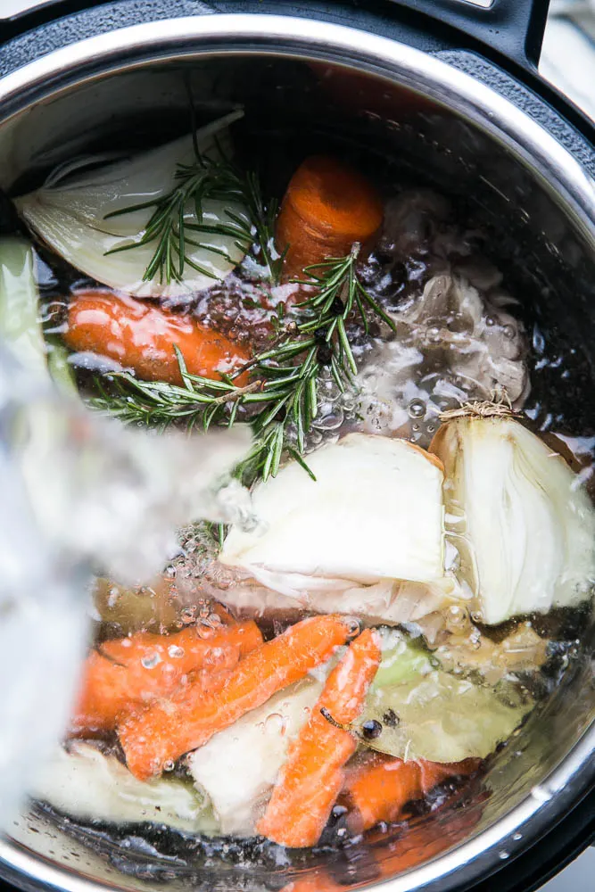 Make homemade chicken bone broth in under 3 hours with your Instant Pot! No more simmering a pot on the stove for an entire day. | perrysplate.com #instantpot #instantpotrecipes #bonebroth