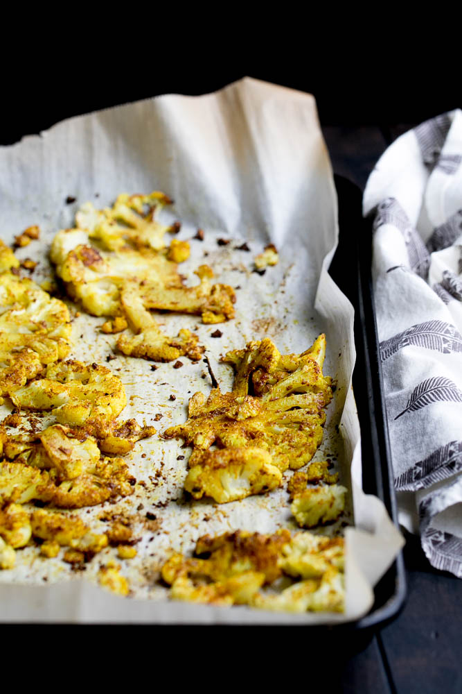 All you need is a head of cauliflower and some curry powder for a quick and easy side dish to serve alongside curry or anything off of the grill! | perrysplate.com #cauliflower #roastedvegetables