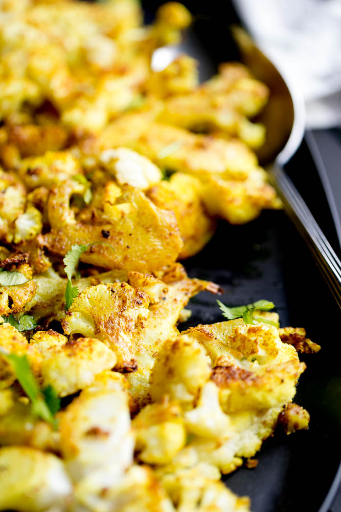 All you need is a head of cauliflower and some curry powder for a quick and easy side dish to serve alongside curry or anything off of the grill! | perrysplate.com #cauliflower #roastedvegetables