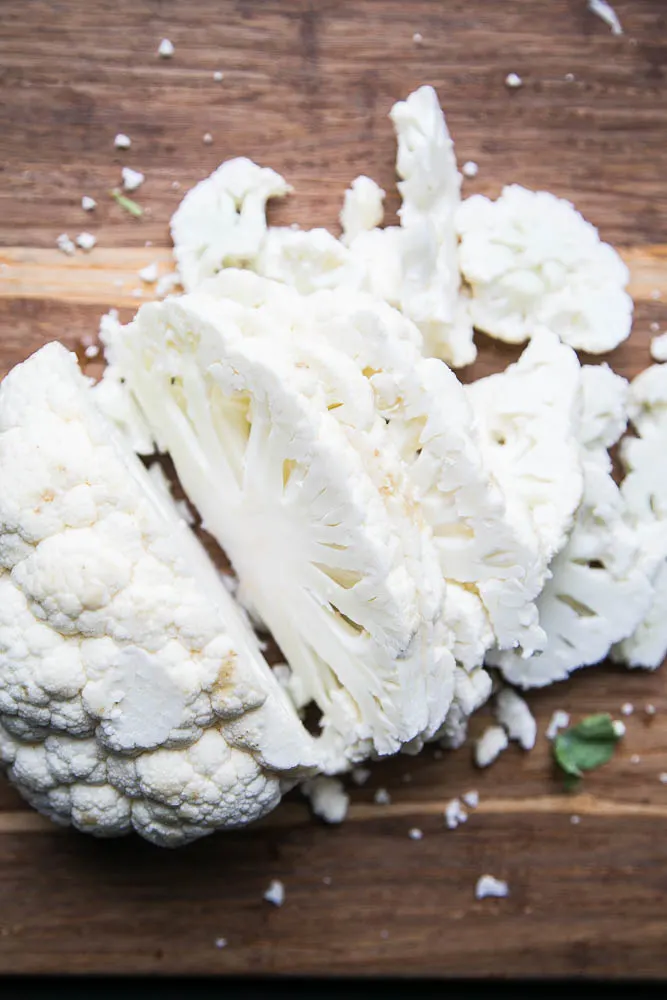 The key to great roasted cauliflower is to cut it in to even "steaks" or planks. They cook more evenly than when you cut it into florets.
