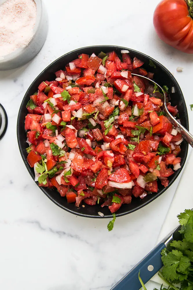 Fresh pico de gallo is easy to make with delicious, ripe tomatoes! Everyone will love this fresh salsa on tacos, salads, or simply with a bag of tortilla chips. | perrysplate.com