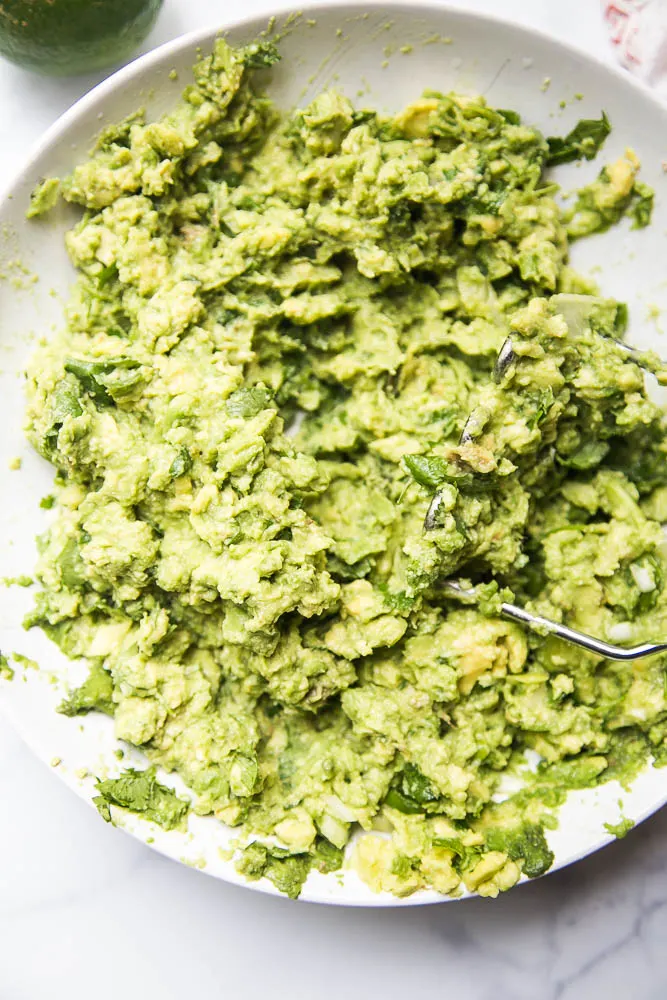 This THE BEST guacamole recipe -- simple, delicious, and great on any tex-mex or Mexican-inspired dish! Also tips on ripening & storing avocados -- perrysplate.com