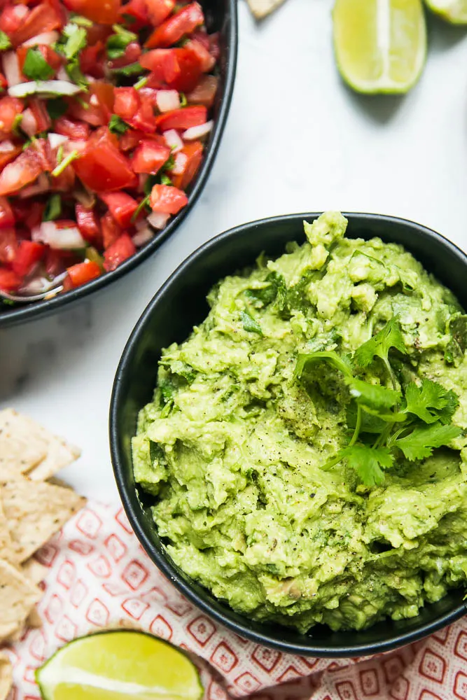 This THE BEST guacamole recipe -- simple, delicious, and great on any tex-mex or Mexican-inspired dish! Also tips on ripening & storing avocados -- perrysplate.com