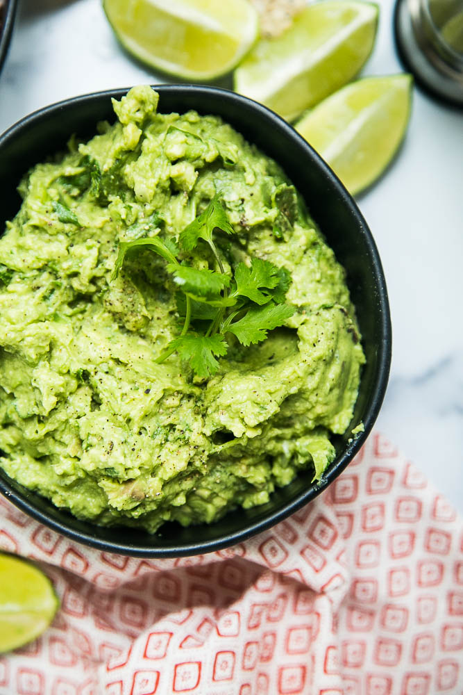 This THE BEST guacamole recipe -- simple, delicious, and great on any tex-mex or Mexican-inspired dish! Also tips on ripening & storing avocados -- perrysplate.com