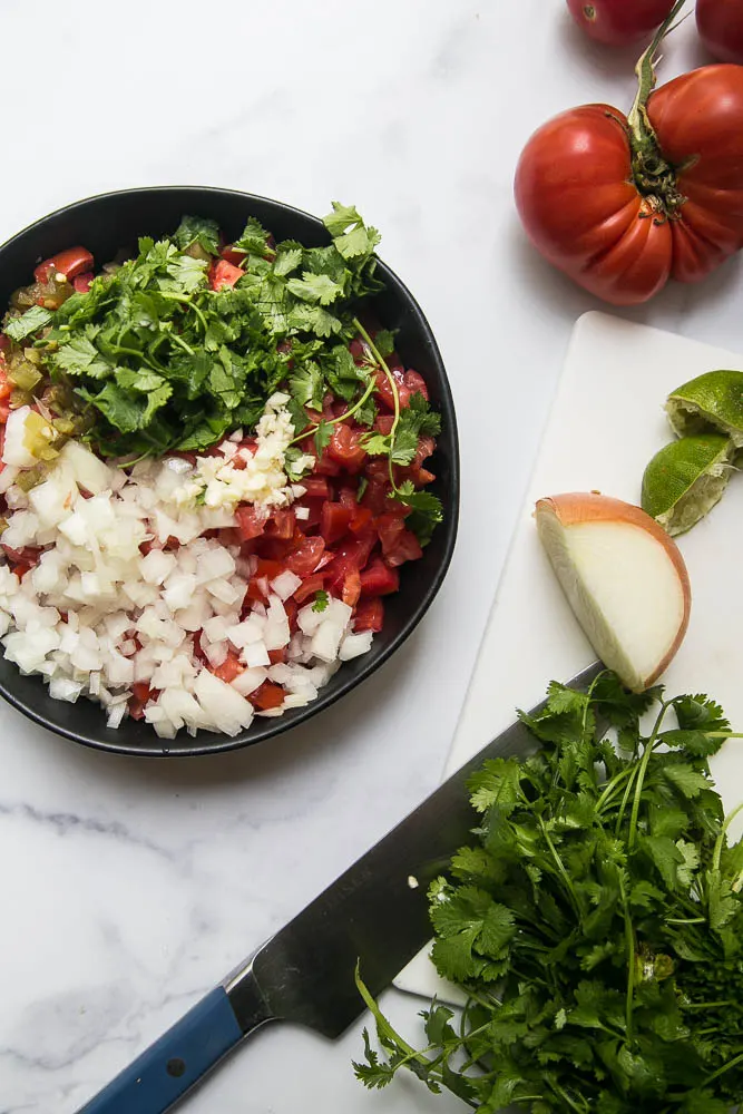 Fresh pico de gallo is easy to make with delicious, ripe tomatoes! Everyone will love this fresh salsa on tacos, salads, or simply with a bag of tortilla chips. | perrysplate.com