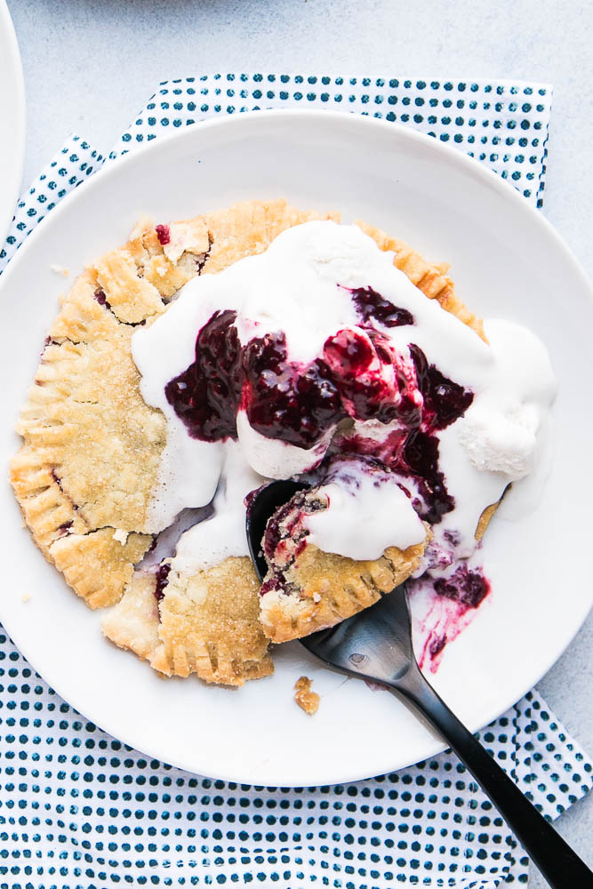 Gluten-Free Berry Hand Pies are made with the best gluten-free pie crust and easy filling! Top them with ice cream and extra berry sauce! | perrysplate.com