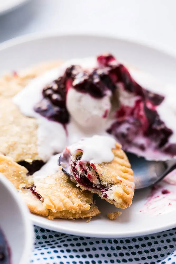 Gluten-Free Berry Hand Pies are made with the best gluten-free pie crust and easy filling! Top them with ice cream and extra berry sauce! | perrysplate.com