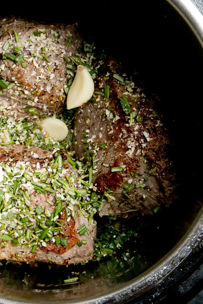 Add lots of fresh rosemary and garlic to your Instant Pot Pot Roast.