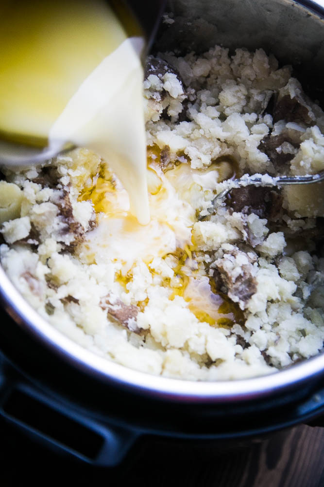 Warm milk and melted butter poured into the partially mashed potatoes.