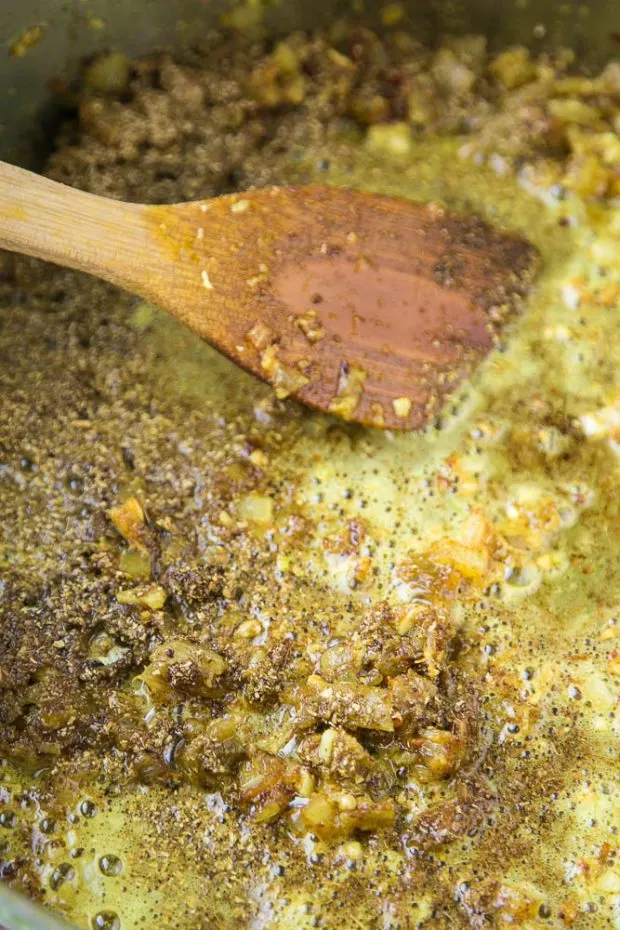 Cook your dry spices in oil to release more aroma and fresher flavors! A blend of Indian spices, garlic, ginger, and onion are sauteeing in a pan in a little oil.