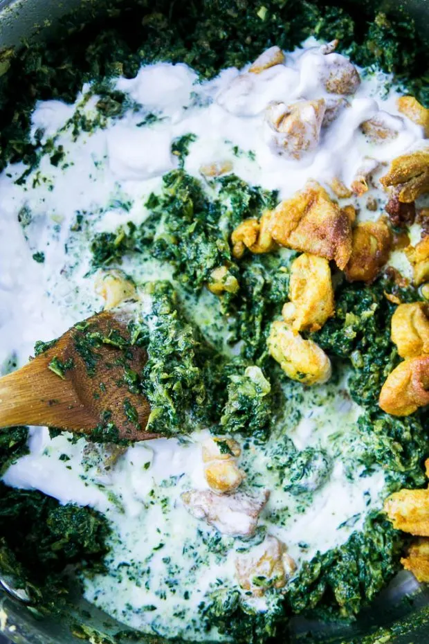 This chicken saag recipe is dairy free using coconut milk. Coconut milk is being added to the pan along with frozen spinach and browned chicken