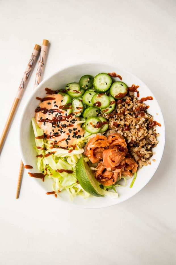 A finished sushi-style bowl using the sriracha lime gravlax, sriracha mayo, roasted cauliflower rice, shredded cabbage, and sliced cucumber.