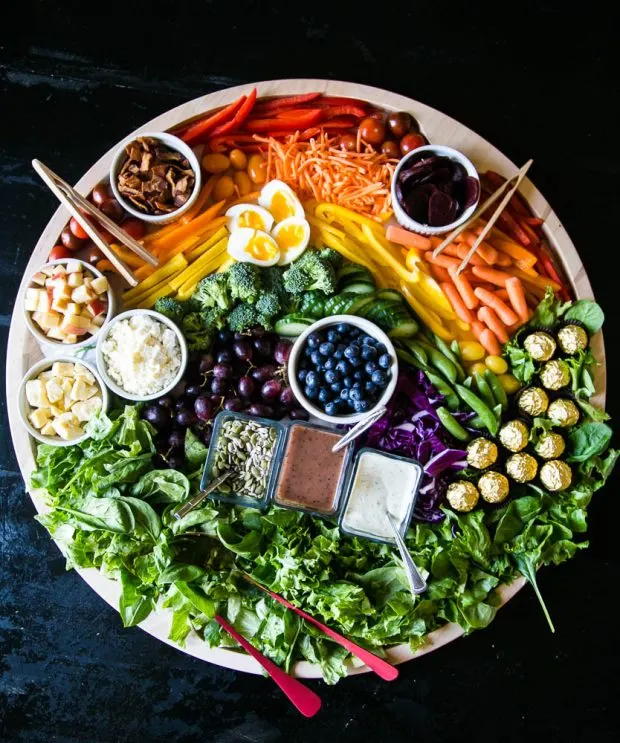 Flatlay image of a rainbow Charcuterie board fill of vegetables and fruit.