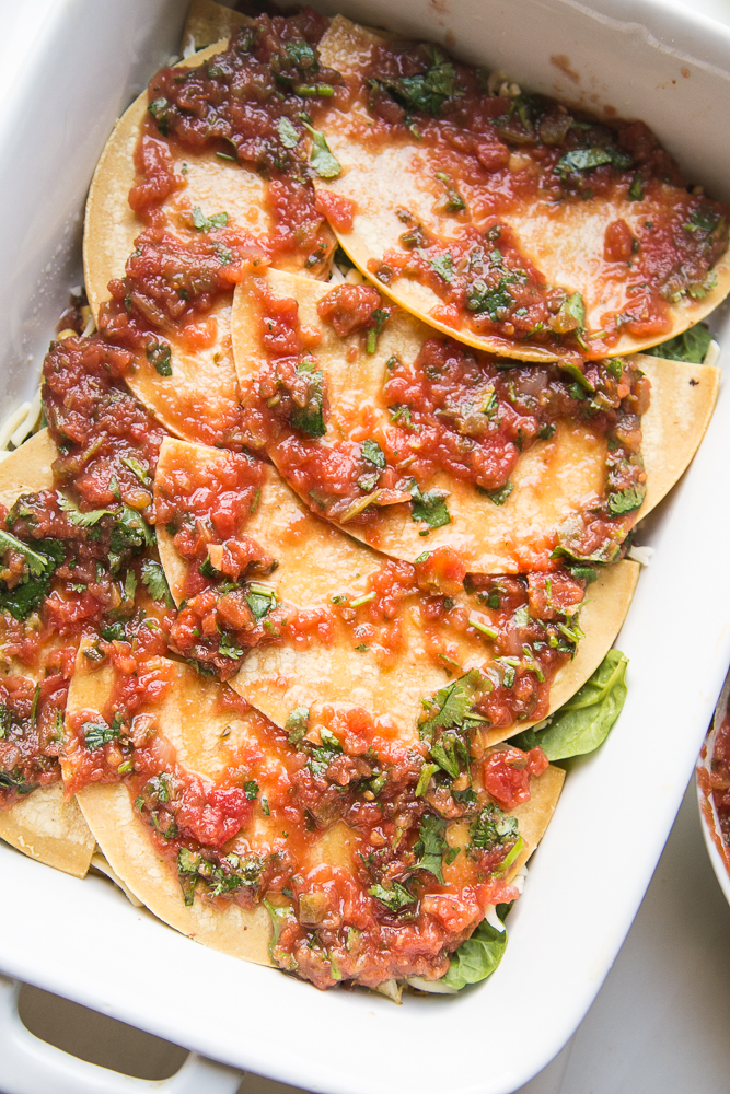 Layering salsa and tortillas for Stacked Roasted Vegetable Enchiladas