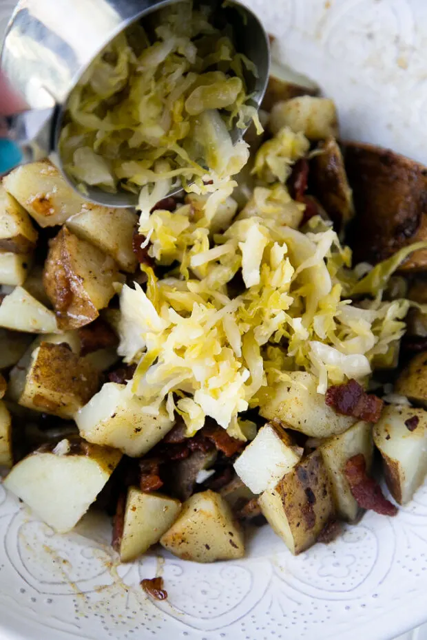 Adding some homemade sauerkraut to the German Potato Salad.