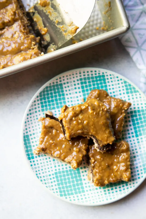 Finished Paleo Samoa Cookie Bars, cut up and served on an aqua plate. 