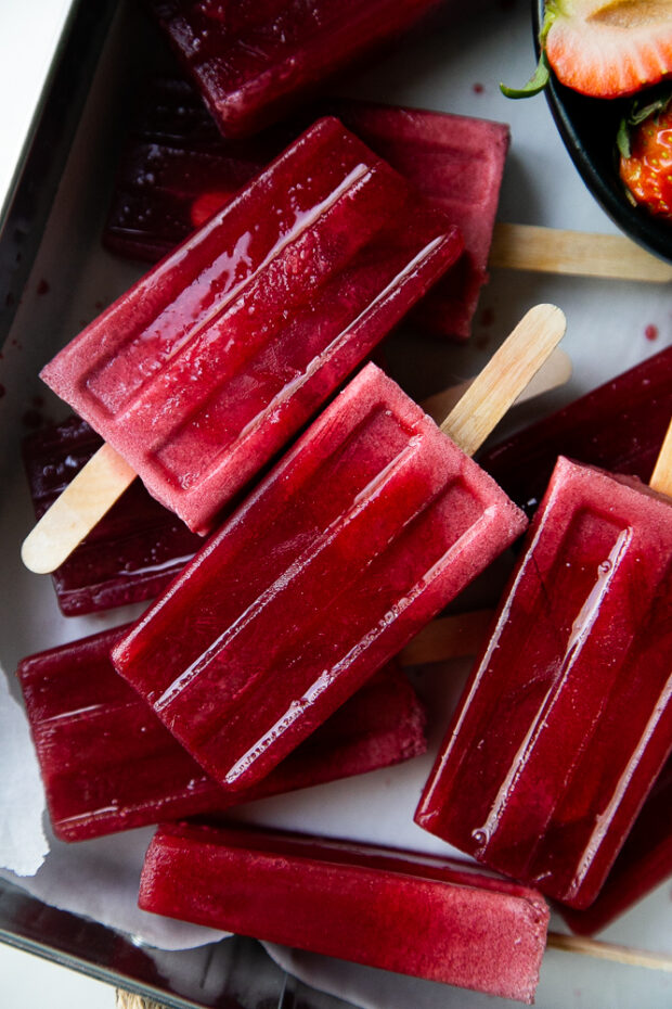 Starbucks Pink Drink Popsicles in a tray with fresh strawberries