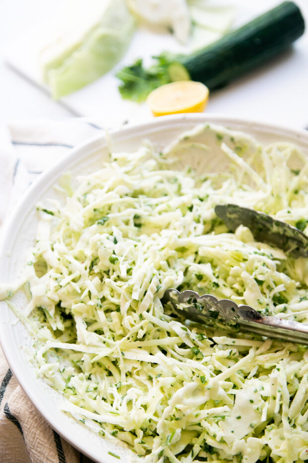 Cabbage Slaw with Cucumber Yogurt Dressing in a large, white serving bowl.