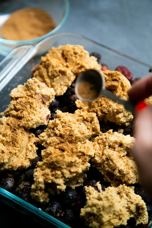 A sprinkle of cinnamon, coconut sugar, and cloves create a cracked snickerdoodle-like topping for the berry cobbler.