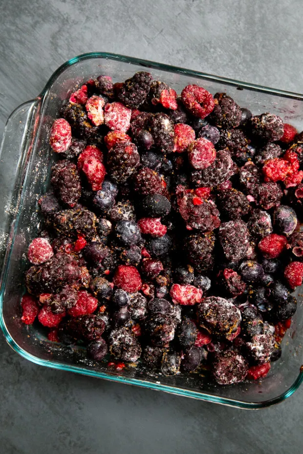 Frozen mixed berries in a pan mixed with coconut sugar, lemon juice, and thickener.