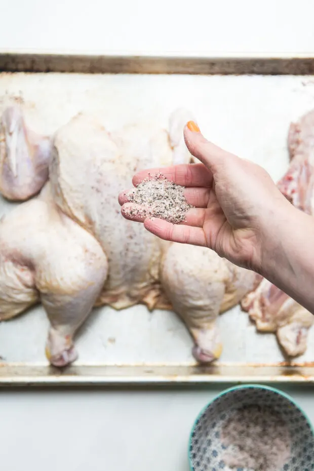 I like to spatchcock my chicken before smoking it so it cooks more quickly. I also use simply salt and pepper to season it.