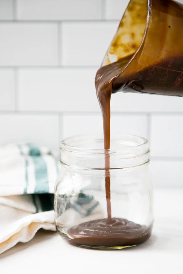 Finished paleo salted caramel sauce poured into a glass jar for storage.